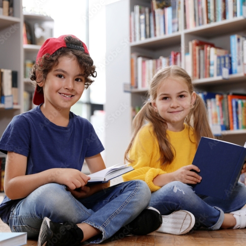 Two girls sitting and reading in the library